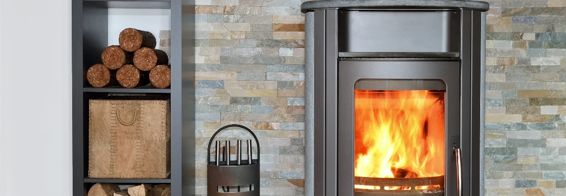 Ein Kamin mit brennendem Feuer und Kaminholzregalen.